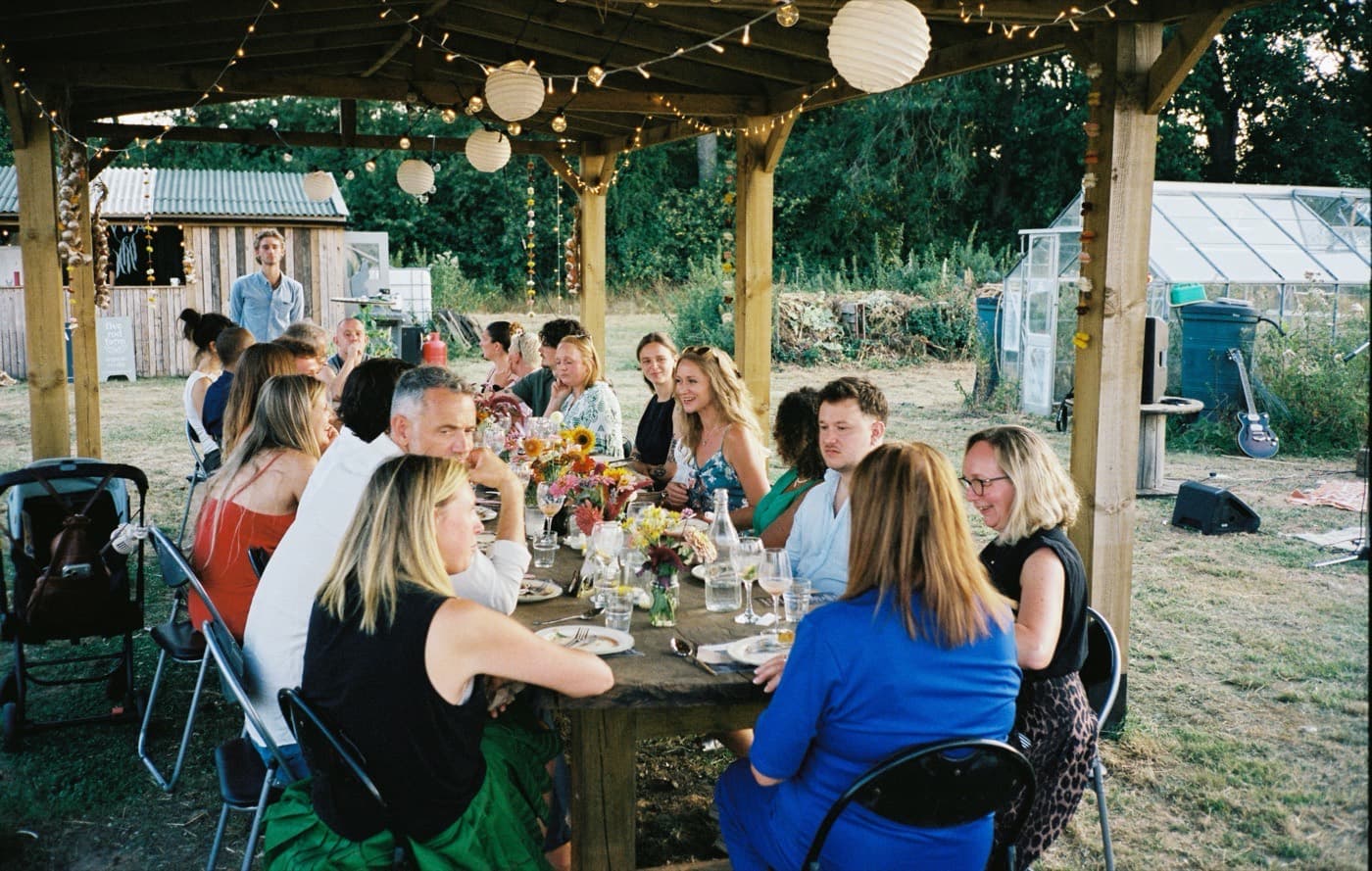 Members and farmers around a table on the farm