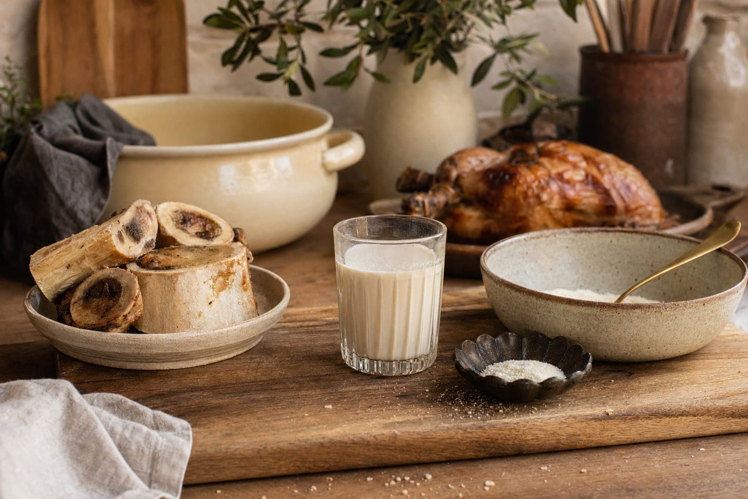 A rustic table with milk, bread and bowls of whole foods in soft light