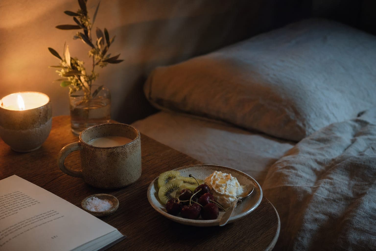 A softly lit bedroom with warm lamplight and linen for evening rest