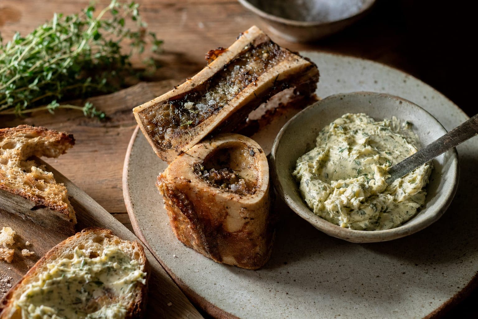 Roasted marrow bones and herb butter on a wooden board