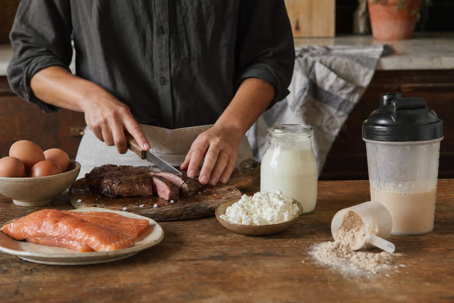 Hands preparing food beside a jug of milk in warm light