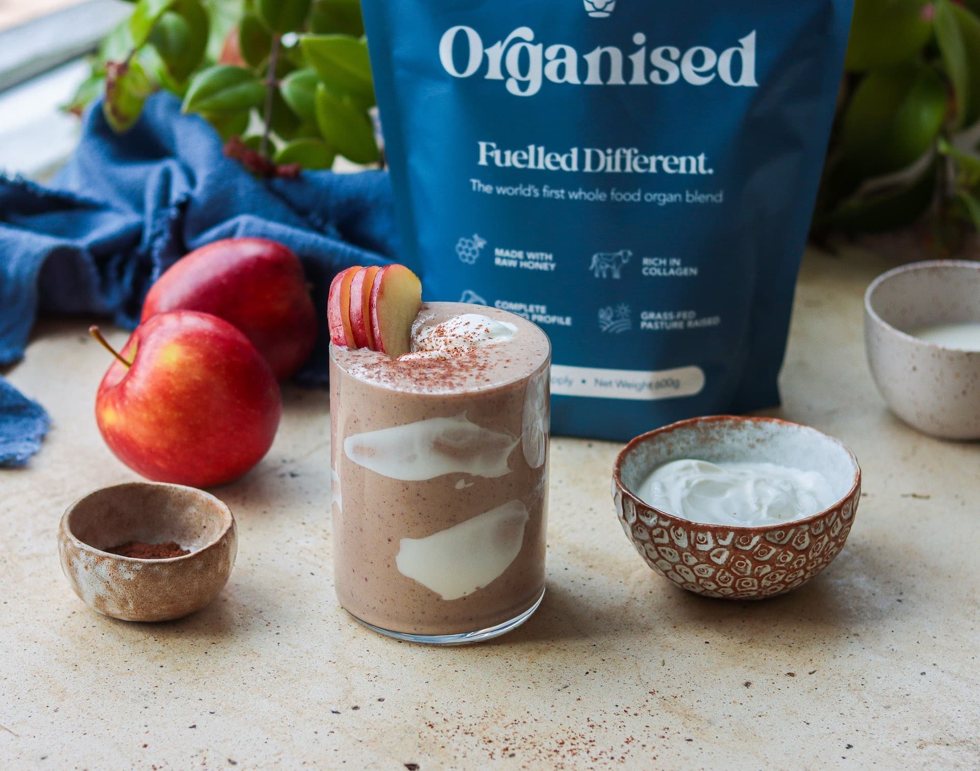 An apple pie smoothie topped with apple slices and cinnamon