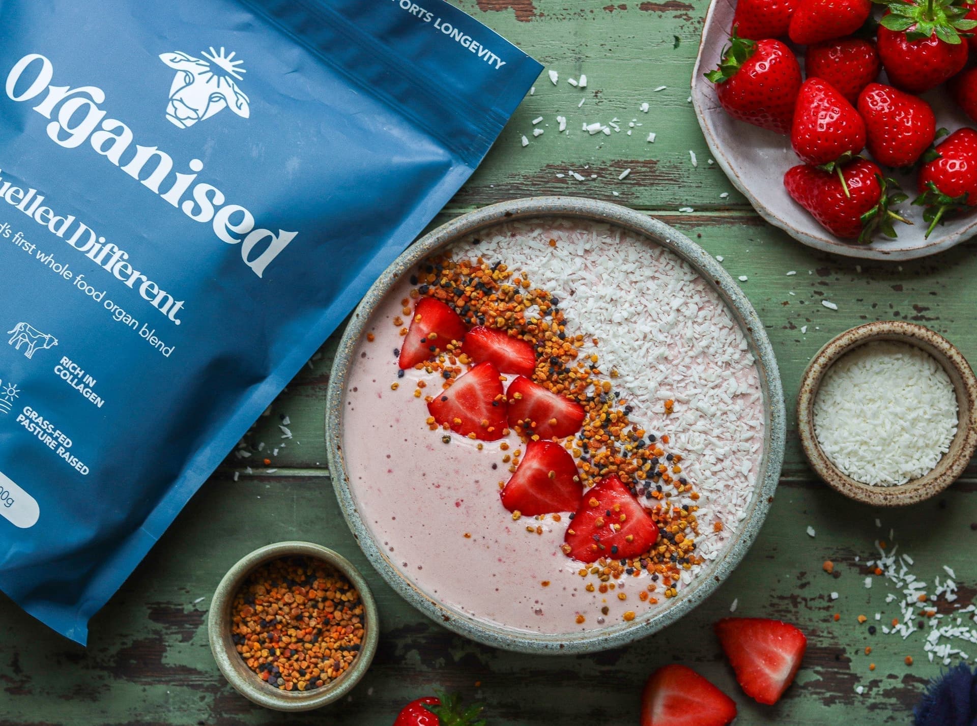 A strawberry smoothie bowl topped with coconut and bee pollen
