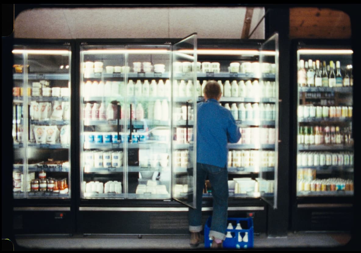 The refrigerated shelf of glass milk bottles in the farm shop