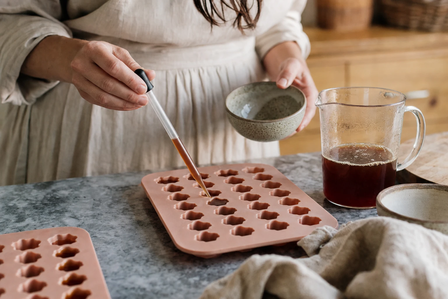 Silicone gummy moulds being filled with the liquid mixture using a pipette
