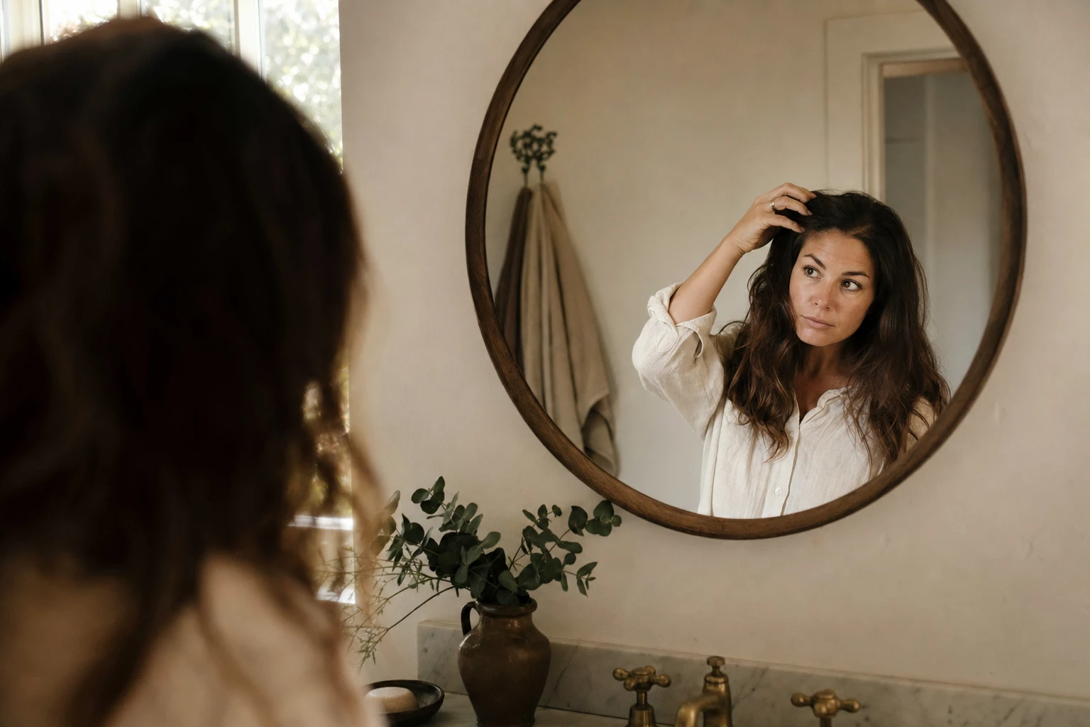 Mother looking in mirror, conveying concern but not despair